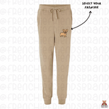 Beige sweatpants with a small dog illustration on a white background with 'Frenchie' branding.